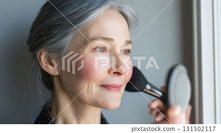 Portrait Of An Elegant Mature Woman Applying Makeup By Window. Embracing Beauty And Self-Care In Later Years 131502117