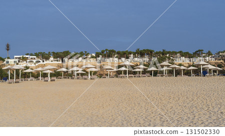 Beach scene with several umbrellas and beach chairs at sunny day Beach scene with several umbrellas and beach chairs at sunny day 131502330