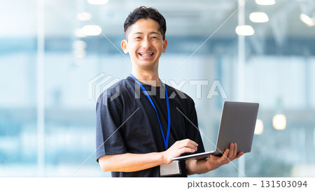 Smiling male businessman with a laptop 131503094