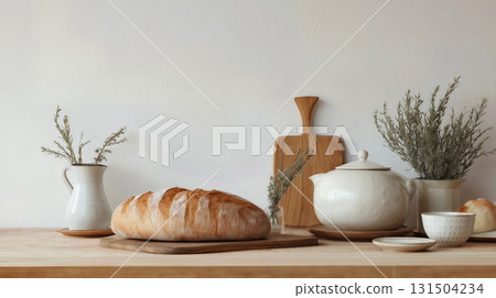 Rustic bread with ceramic teapot and dishes on a wooden table. 131504234