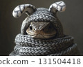 Cute snake dressed in a knitted hat with bunny ears and a scarf. 131504418
