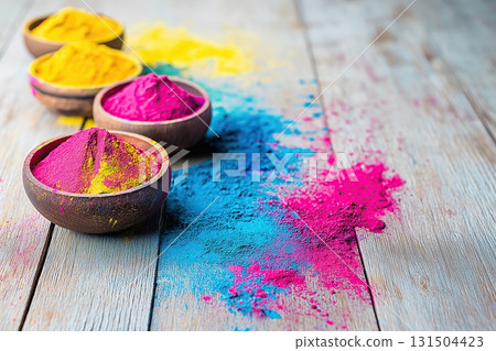 Bowls of colorful Holi powder scattered on wooden surface 131504423