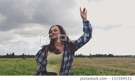 Beautiful girl dancing around in summer nature outside. Happy young woman outdoors. Playful woman in blue shirt turning around in summer nature outside. Beautiful girl dancing around in summer nature outside. Happy young woman outdoors. Playful woman in blue shirt turning around in summer nature outside. 131504531
