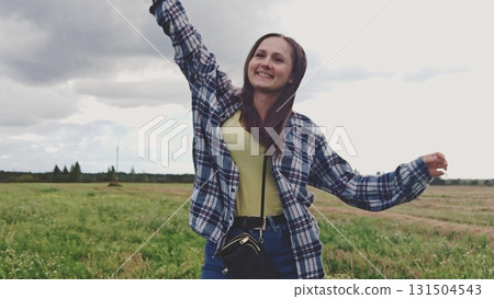 Beautiful girl dancing around in summer nature outside. Happy young woman outdoors. Playful woman in blue shirt turning around in summer nature outside. Beautiful girl dancing around in summer nature outside. Happy young woman outdoors. Playful woman in blue shirt turning around in summer nature outside. 131504543
