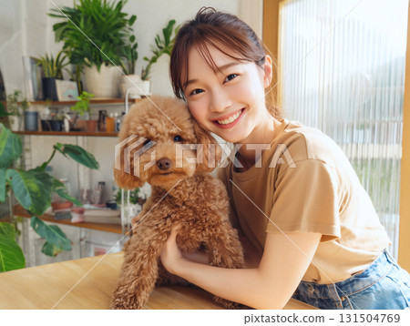 美容沙龍裡，一位微笑的女子抱著一隻可愛的玩具貴賓犬。寵物美容 131504769