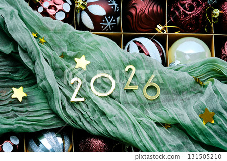 New Year's background with a box of Christmas tree toys and green drapery. New Year's background with a box of Christmas tree toys and green drapery. 131505210