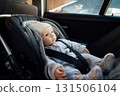Baby sitting in an infant car seat, safety travelling by car with little child. Little baby fastened with seat belt in safety car seat. Road trip lifestyle child care transportation rear-facing. 131506104
