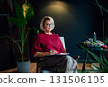 Woman drawing work-life balance wheel sitting on armchair at cozy dark home interior. Self-reflection and life planning for next new year. Personal Year review. Coaching tools. Finding Balance in Life 131506105