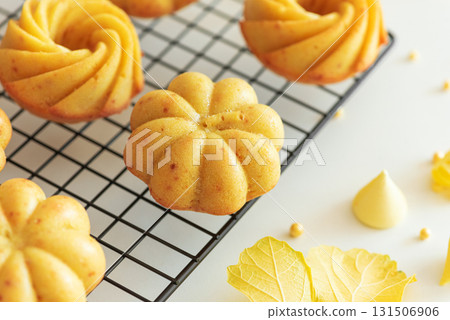Autumn-Themed Mini pumpkin Cakes with Seasonal Decorations on White Background 131506906
