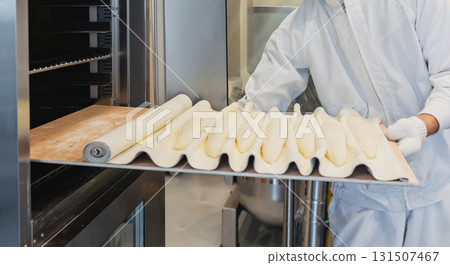 麵包師將法國麵團放入烤箱 麵包師將法國麵團放入烤箱 131507467