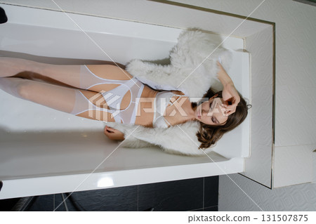Woman relaxing in hotel bathtub dressed in elegant lingerie Woman relaxing in hotel bathtub dressed in elegant lingerie 131507875