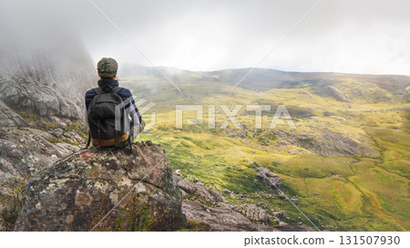Young woman in sports clothing sitting on rocks enjoying the scenery of Andringitra national park, large stones massif background, during hike to pic Boby peak 131507930