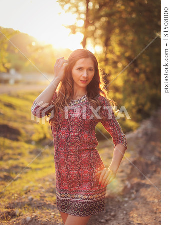 Portrait of young woman in casual summer dress, strong sunset backlight with nice bokeh 131508000