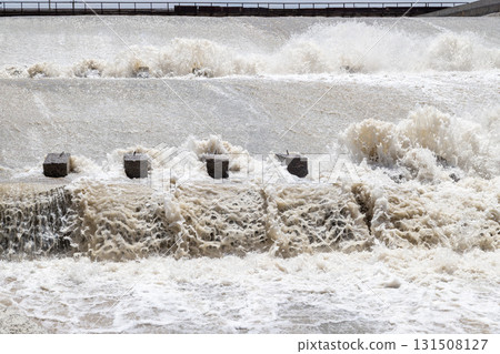 Turbulent water flowing over concrete blocks at dam Turbulent water flowing over concrete blocks at dam 131508127