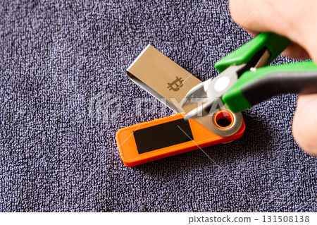 hardware Bitcoin wallet with wire cutters indoors 131508138