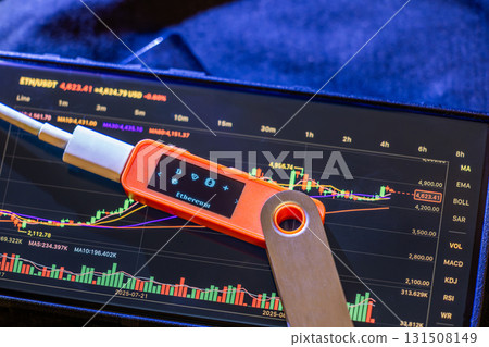 Hardware wallet showing Ethereum with tablet and USB cable indoors 131508149