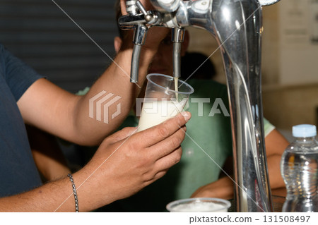 barman hand at beer tap pouring a draught lager beer serving in a restaurant or pub barman hand at beer tap pouring a draught lager beer serving in a restaurant or pub 131508497
