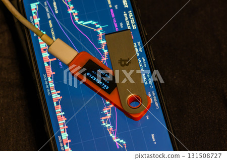 Hardware security key and smartphone displaying cryptocurrency data Hardware security key and smartphone displaying cryptocurrency data 131508727