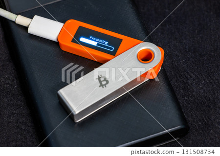 Close-up of hardware wallet and USB drive processing transaction indoors 131508734