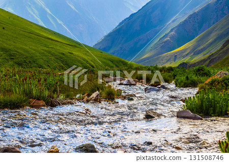 Serene stream flowing through rocky mountainous region in daylight in Kyrgyzstan 131508746