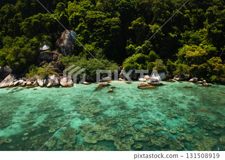 Crystal clear waters offer views of vibrant coral reefs next to lush green jungles on the Perhentian Islands in Malaysia. Crystal clear waters offer views of vibrant coral reefs next to lush green jungles on the Perhentian Islands in Malaysia. 131508919