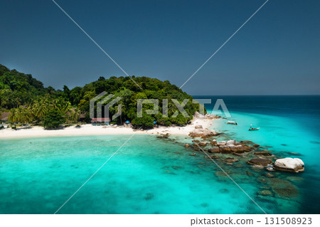 A bright beach with clear turquoise waters and lush greenery on a sunny day on the island of Lang Tengah in Malaysia 131508923