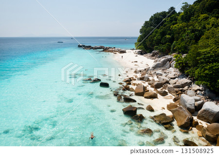 A picturesque beach with clear water and rocky coastline on a sunny day on the island of Lang Tengah in Malaysia A picturesque beach with clear water and rocky coastline on a sunny day on the island of Lang Tengah in Malaysia 131508925