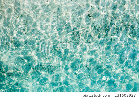 Clear turquoise water reflecting sunlight creates beautiful patterns in a shallow beach setting during a bright afternoon Clear turquoise water reflecting sunlight creates beautiful patterns in a shallow beach setting during a bright afternoon 131508928