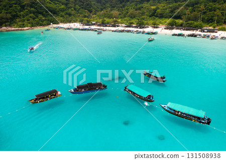 Parked boats in the sea near Turtle Beach on Redang Island in Malaysia. Top view of boats in turquoise waters near a tropical island Parked boats in the sea near Turtle Beach on Redang Island in Malaysia. Top view of boats in turquoise waters near a tropical island 131508938