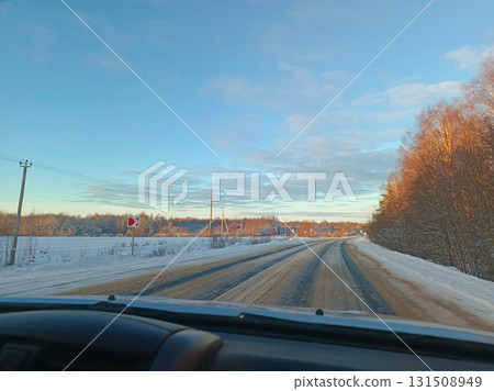 A car is driving down a snowy road. A car is driving down a snowy road. 131508949