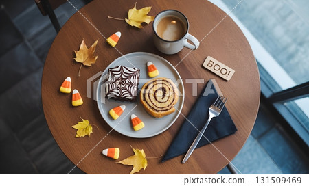 Halloween treats on a coffee table with autumn leaves, top-down flat lay with candy, and festive decor 131509469