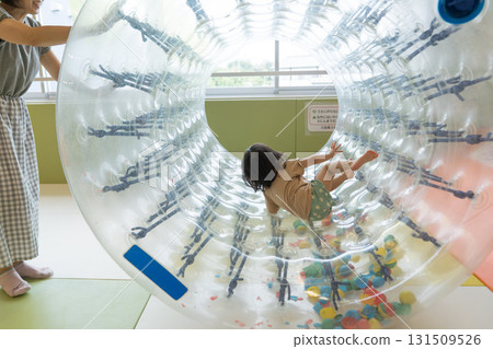 Toddler girl playing with indoor play equipment Toddler girl playing with indoor play equipment 131509526