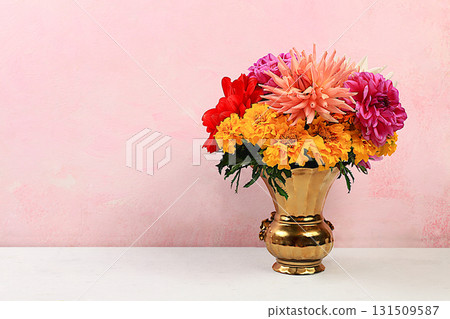 Bouquet of beautiful dahlias and marigolds on an old pink background in grunge style, abstract floral arrangement, spring or autumn background with space for text, minimal holiday concept, discreet Bouquet of beautiful dahlias and marigolds on an old pink background in grunge style, abstract floral arrangement, spring or autumn background with space for text, minimal holiday concept, discreet 131509587