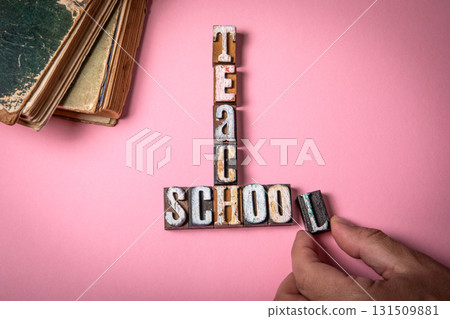 Teach and School Concept. Vintage wooden letter blocks on a pink background Teach and School Concept. Vintage wooden letter blocks on a pink background 131509881
