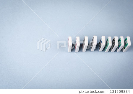 Dominoes in a Line Ready to Fall on a Blue Surface Dominoes in a Line Ready to Fall on a Blue Surface 131509884