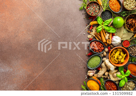 A diverse collection of vibrant spices and herbs, elegantly positioned on a brown backdrop, exuding natural beauty and a burst of fragrances 131509982