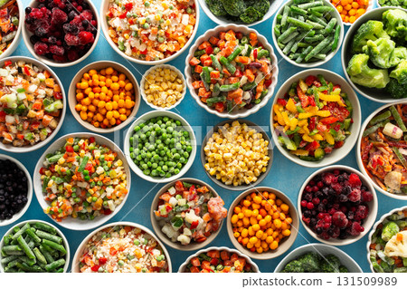 Fresh vegetables frozen in summer, neatly arranged in plates, ready for winter meals, showcasing vibrant colors and healthy options for future cooking, , vegetables in plates on a blue background 131509989