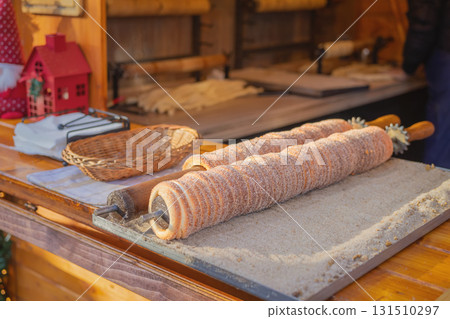 Traditional East Europe Christmas sugar dessert chimney cake, trdlo or trdelnik, sweet aromatic winter seasonal street food with cinnamon and spices Traditional East Europe Christmas sugar dessert chimney cake, trdlo or trdelnik, sweet aromatic winter seasonal street food with cinnamon and spices 131510297