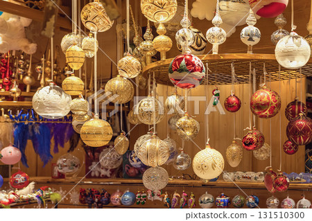 Sparkling Christmas ornaments and baubles hanging in festive market stall. Concept of Christmas decoration, holiday spirit, festive ornament tradition Sparkling Christmas ornaments and baubles hanging in festive market stall. Concept of Christmas decoration, holiday spirit, festive ornament tradition 131510300