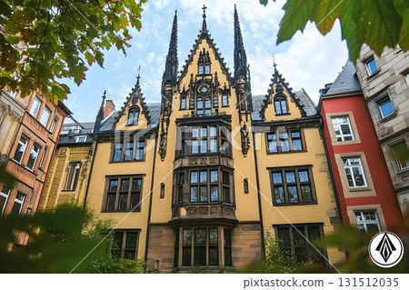 Ornate Yellow Building with Gothic Architecture and Leafy Framin 131512035