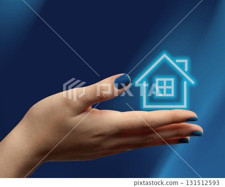 Female hand holding neon house icon representing real estate market 131512593