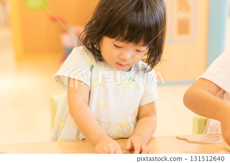 Toddler girl playing with puzzles Toddler girl playing with puzzles 131512640