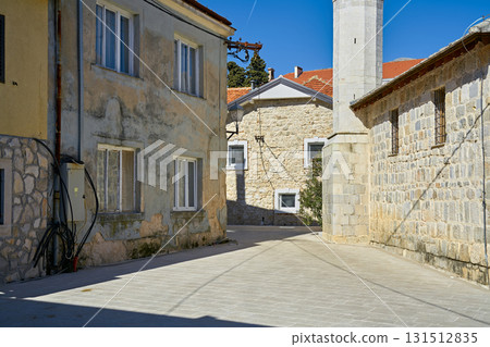 Narrow Stone Alleyway with Historic Mediterranean Architecture and Strong Shadows on a Sunny Day Narrow Stone Alleyway with Historic Mediterranean Architecture and Strong Shadows on a Sunny Day 131512835