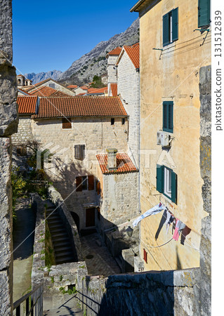 View Over Terracotta Roofs and Stone Houses Towards Rocky Mountains in a Mediterranean Old Town 131512839
