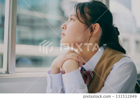 A female junior high school student gazing out the window 131512849
