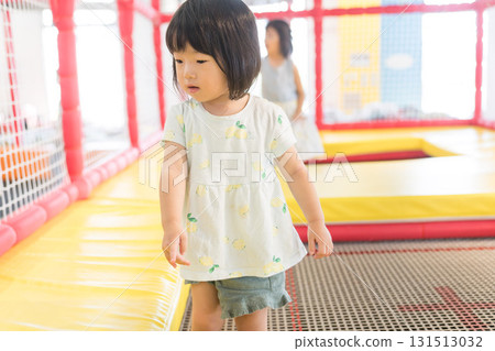 蹣跚學步的女孩在彈跳床上玩耍 131513032