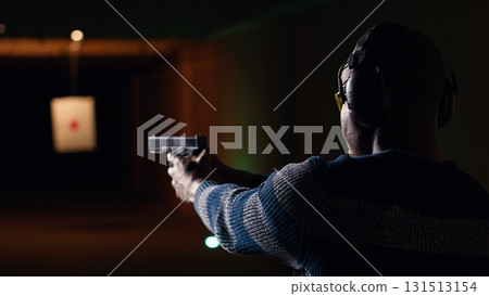 Portrait of smiling man doing training in shooting range, learning proper pistol holding etiquette and having fun. Cheerful gun hobbyist practicing with weapons, wearing protective eyewear, camera B Portrait of smiling man doing training in shooting range, learning proper pistol holding etiquette and having fun. Cheerful gun hobbyist practicing with weapons, wearing protective eyewear, camera B 131513154