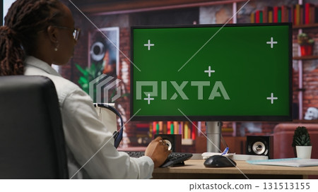 Student at home browsing internet on green screen computer, doing homework, researching information online. Girl in apartment reading articles on mockup PC for school tasks, camera B Student at home browsing internet on green screen computer, doing homework, researching information online. Girl in apartment reading articles on mockup PC for school tasks, camera B 131513155
