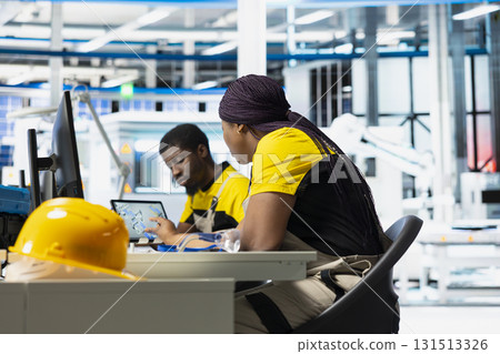 Solar panels manufacturing plant engineer develops new photovoltaic materials and technologies on a pc setup. Factory technician conducting inspection for finetuning production. 131513326
