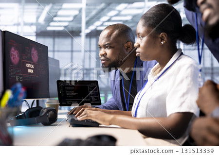 Team of programmers in server hub doing brainstorming, working to protect equipment from hacker. IT staff members facility in data center struggling to fix security breach alert 131513339
